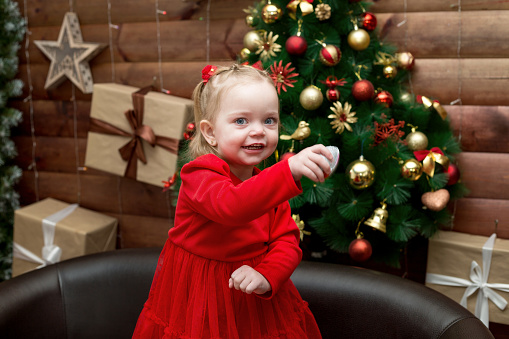 Dance of a little girl on Christmas night near the Christmas tree.