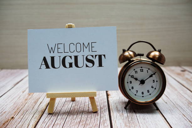istock Welcome August text message with alarm clock on wooden background 1405200081