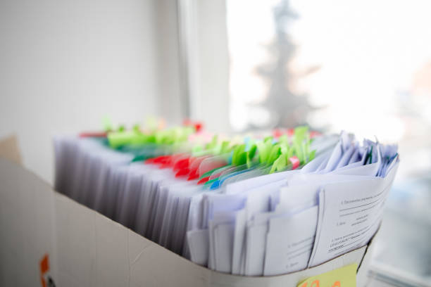 istock Stack of business report paper file on modern white office desk with bokeh background. 1405201607