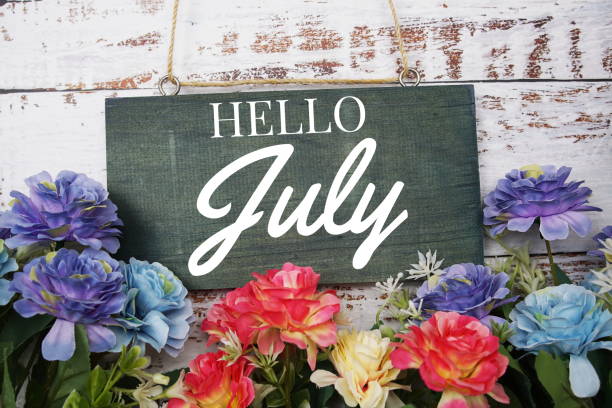 istock Hello July typography text decorate with flower on wooden background 1405202705