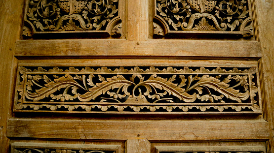 wood carving, floral pattern carved on wooden background. gebyok