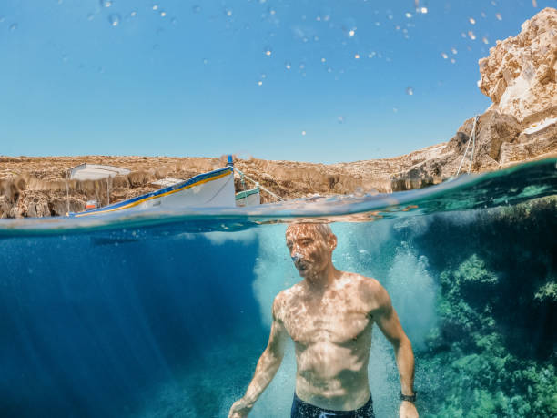 istock Underwater shot of diver breaking water surface 1405205748