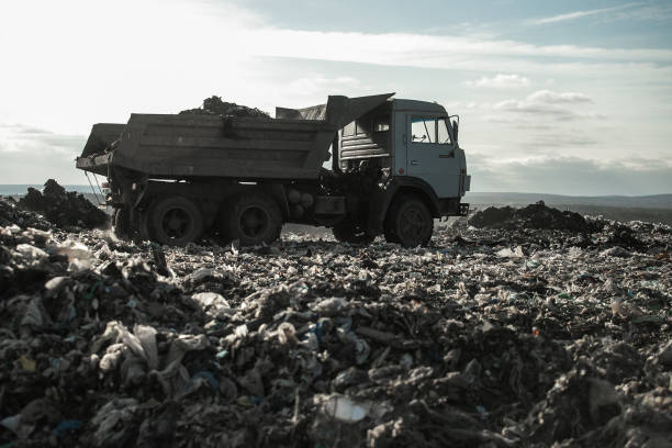 Recycling concrete and construction waste from demolition. Excavator at landfill of the disposa. Reuse of building rubble. Backhoe dig gravel at mining quarry on sunset background. Concrete debris stock photo