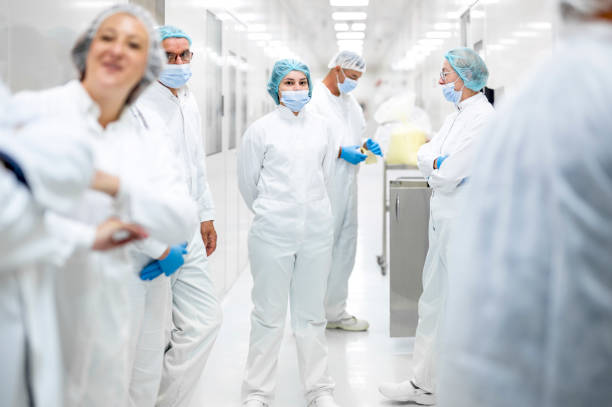 istock Workers in protective equipment in the pharmaceutical industry seen on shift in the hallway of the production plant 1405216829