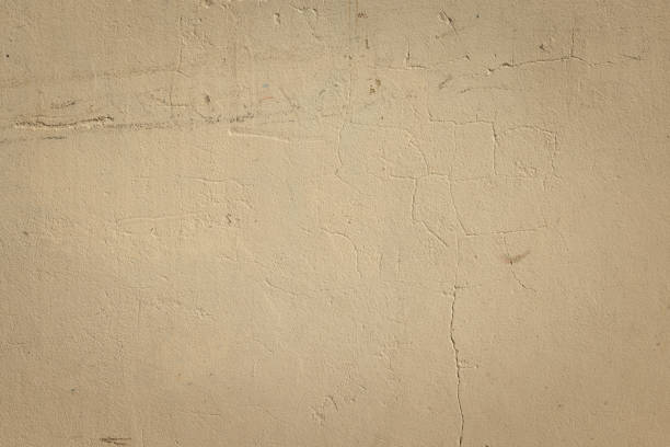 Part of a textured beige concrete wall.