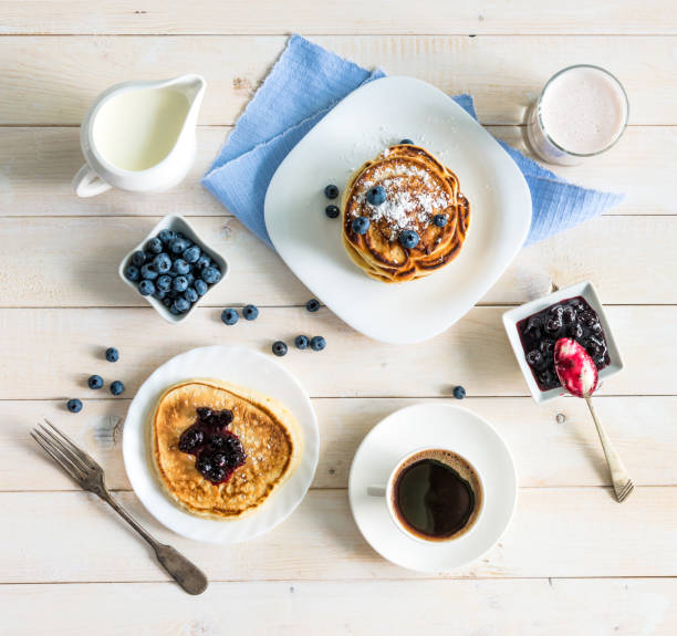 pancakes with blueberry and coffee on wooden background. top view