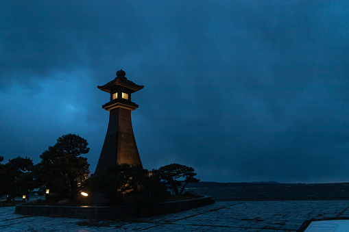 Matsue, Shimane, Japan - Dec 1 2021 : Illuminated Aoyagirou-no-daitourou (or ootourou, Aoyagirou's big lantern) at Shirakata Park at stormy evening.