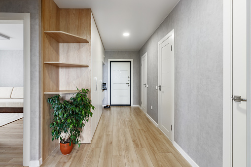 Entrance hall in a new apartment with a white wardrobe and shoes standing near the front door