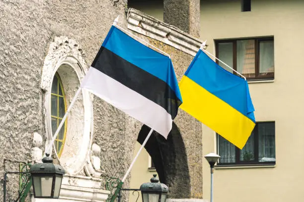 Flag of Estonia and Ukraine waving together on the wall of a building