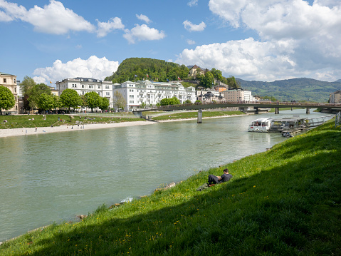 The river Salzach in Salzburg, Austria on a bright spring morning.  In the background are church spires and hotels.