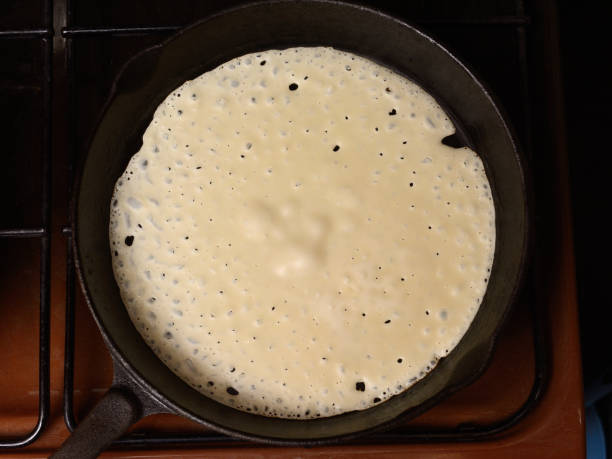 istock Pancakes baking in a hot frying pan, close-up view from above 1405232275