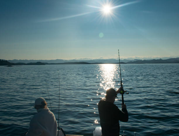 Couple with fishing rod on a boat in the ocean near Stavanger Norway (jig fishing) Couple with fishing rod on a boat in the ocean near Stavanger Norway (jig fishing) hook of holland stock pictures, royalty-free photos & images