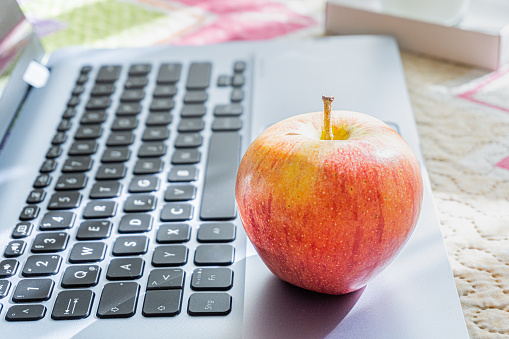 Close-up, apple on laptop, healthy snack based on fruit