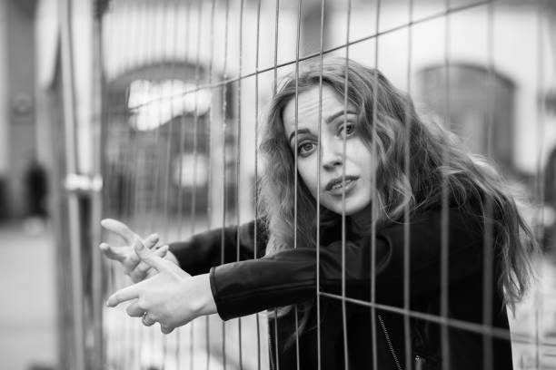 istock girl behind bars 1405236940