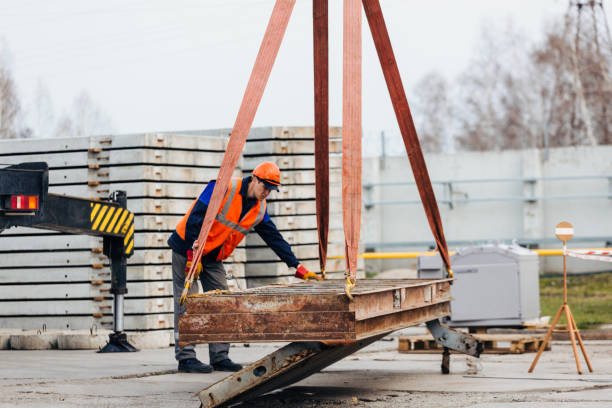 istock Slinger in helmet and vest controls unloading of metal structures on construction site. 1405239841