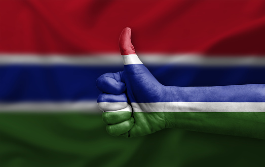 Hand making thumb up painted with flag of gambia