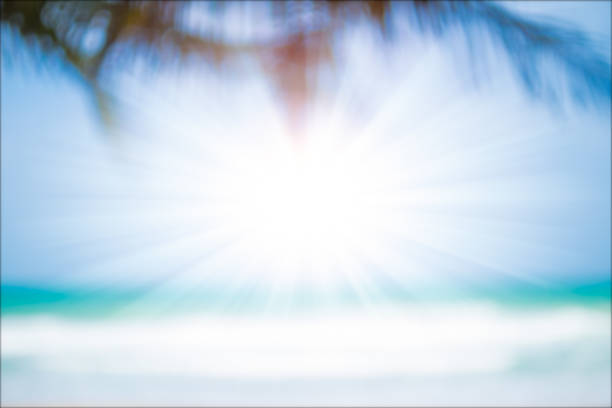 Blurred image of tropical beach with sun light abstract background. Summer vacation concept.