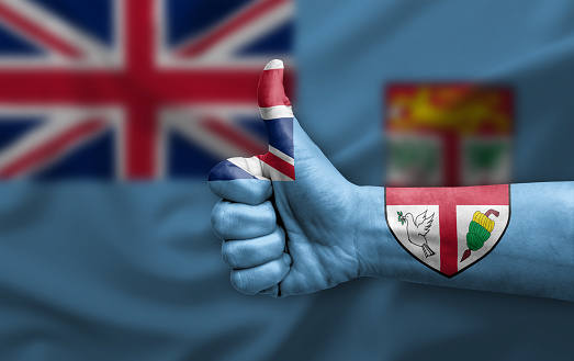 Hand making thumb up painted with flag of fiji