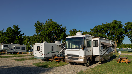 Rv campers at campsites on a sunny morning with blue skies