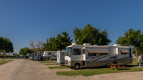 Rv campers at campsites on a sunny morning with blue skies