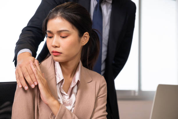 Selective focus at women face. Young beautiful women office worker sitting with hand of men touch her body. Sexual harassment in workplace, discrimination of women concept. Selective focus at women face. Young beautiful women office worker sitting with hand of men touch her body. Sexual harassment in workplace, discrimination of women concept. seduction stock pictures, royalty-free photos & images