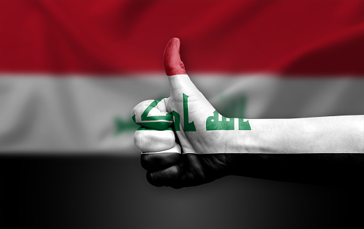 Hand making thumb up painted with flag of iraq
