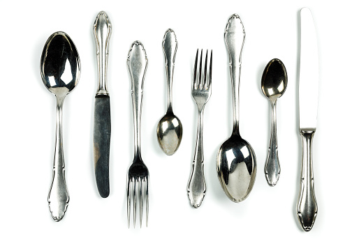 Silverware set against white background with a soft shadow. Really silver pieces with ancient marks and texture. Clipping path