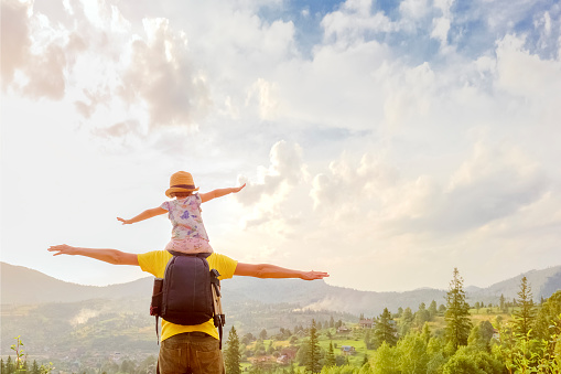 Piggyback ride father child travel mountain kids freedom child on shoulders dad and daughter father walking hiking trip nature kid arms spread out. Freedom mountain children hiking trail walking hills.