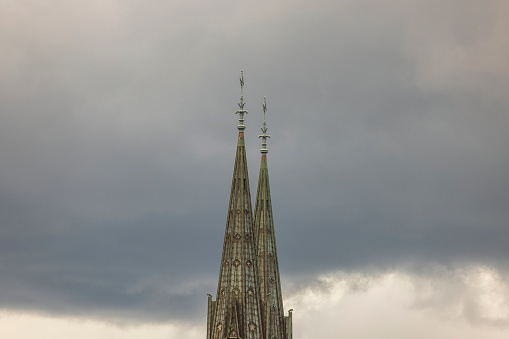 Close up view of top towers of Uppsala Cathedral Church on pale sky background. Sweden.