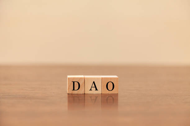 istock DAO characters. Decentralized autonomous organization. Written on three wooden blocks. Black letters. 1405245609