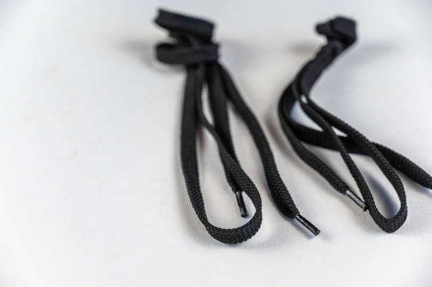 istock Black laces against a neutral background. Two Flat Laces with tied knot. Close-up. Selective focus. 1405246058