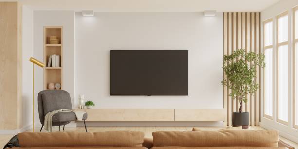 white wall mounted tv on cabinet in living room with dark brown armchair and brown sofa,minimal design. - flat screen audio imagens e fotografias de stock