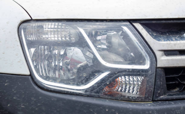 istock Front right headlight for Renault Duster. Crossover or SUV in white with a black bumper. View of the front of the car. Detailed close-up light on a car. Exterior detail. 1405246930