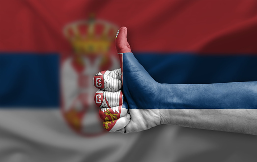 Hand making thumb up painted with flag of serbia