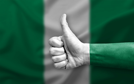 Hand making thumb up painted with flag of nigeria