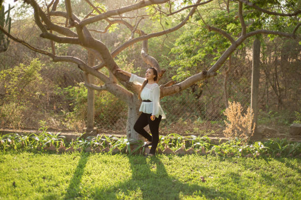 istock Young woman leaning against a plum tree. 1405247504