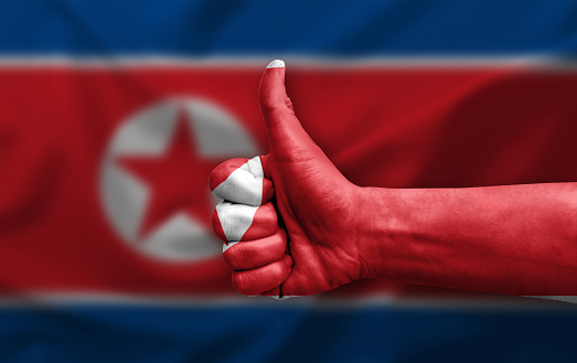 Hand making thumb up painted with flag of north korea