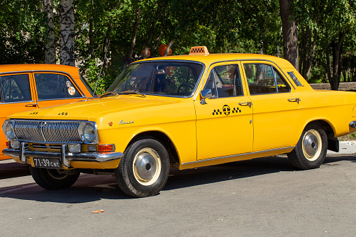 Moscow, Russia - July 20, 2021: The old Soviet car GAZ-24. Yellow car of Volga brand as a taxi