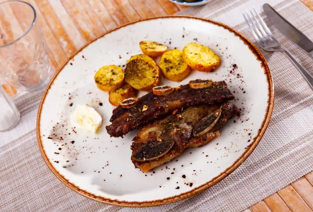 Photo of Churrasco grilled veal ribs with baked potatoes and garlic aioli