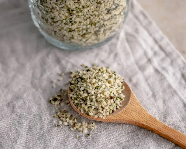 Close-up of hemp seeds on a wooden spoon