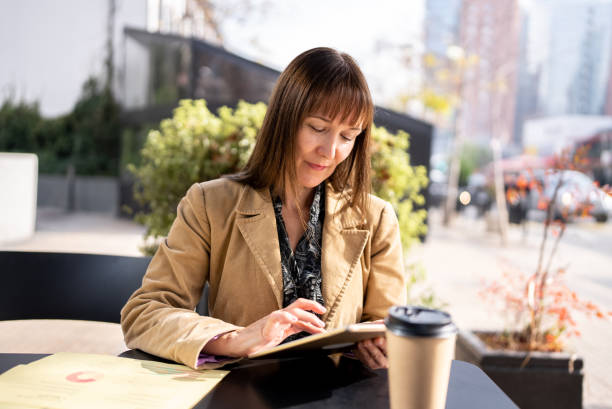 istock Mature businesswoman using digital tablet in a restaurant 1405261007