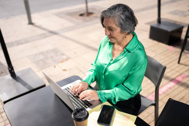 istock Mature businesswoman using laptop in a restaurant 1405261028