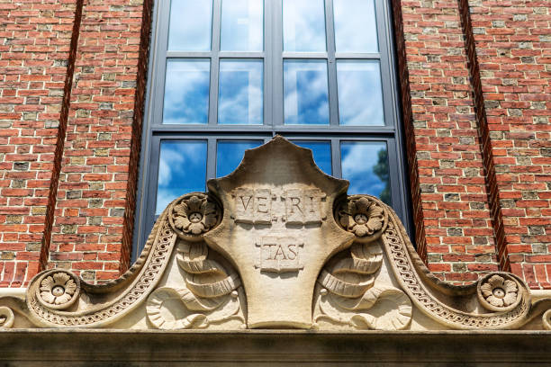 Cambridge, Massachusetts, USA - June 24, 2022: Close-up of the Harvard University motto on a sculpted stone atop a building entrance. The motto is the Latin word \