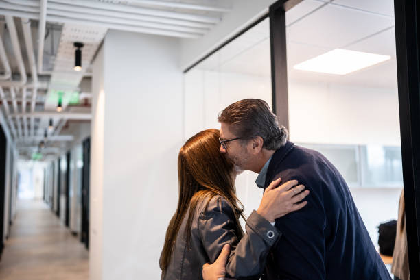 Senior businessman greeting employee in the office Senior businessman greeting employee in the office kissing on the mouth stock pictures, royalty-free photos & images