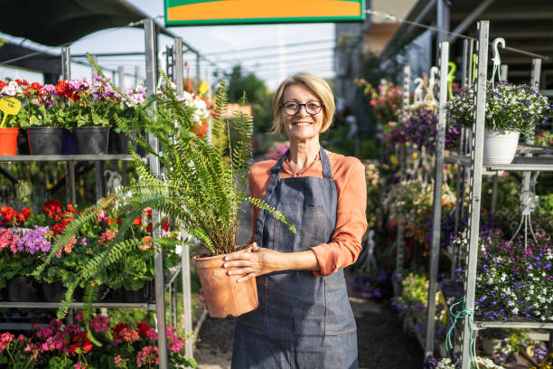 female florist in garden center - garden center flower women plant imagens e fotografias de stock