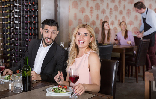 Elegant romantic couple enjoying wine on date in a restaurant