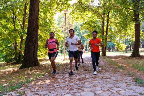 istock Group Of Friends Jogging Through The Park 1405265489
