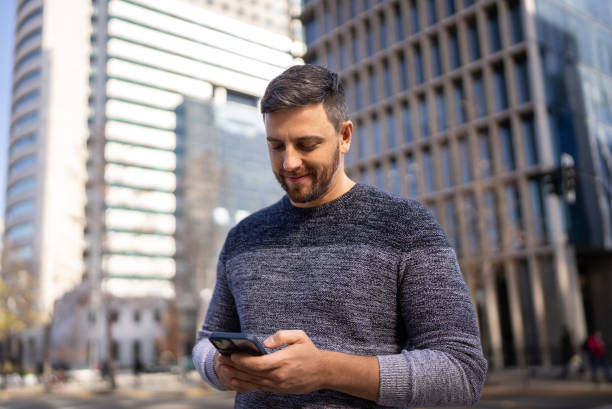Mid adult man using mobile phone outdoors