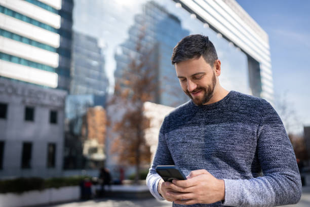 istock Mid adult man using mobile phone outdoors 1405265638