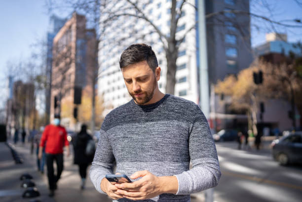 istock Mid adult man using mobile phone outdoors 1405265640